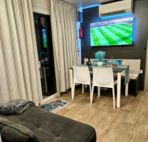 a living room with a table with chairs and a tv at Mobile House 4 you, Murter - Slanica in Murter