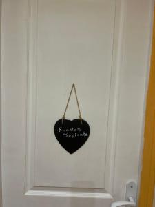 a black heart hanging on a white wall at Les Prunus Clermont -Créans 2 personnes in Clermont-Créans