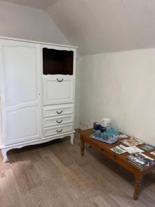 a room with a white dresser and a coffee table at Les Prunus Clermont -Créans 2 personnes in Clermont-Créans