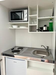 a small kitchen with a microwave and a sink at ElbUfer Glück in Schieritz