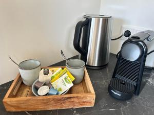 a cutting board with cups and a coffee maker on a counter at Vida Bonita in Den Burg