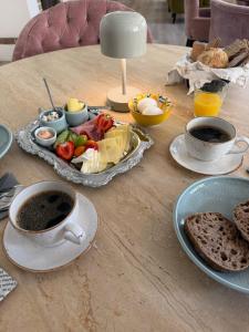 a table with a plate of food and a cup of coffee at Seaside Stay Haverdal in Haverdal