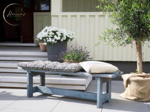 a blue bench with a pillow and flowers on it at Seaside Stay Haverdal in Haverdal