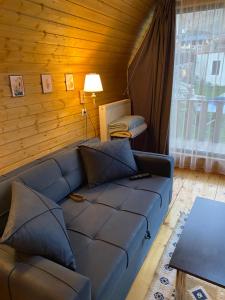 a living room with a blue couch and a table at Sunny Side Cottage in Kazbegi +26 photos