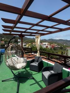 a balcony with chairs and a swing on a roof at Casa colon in Los Silos