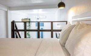 a bedroom with a bed with white pillows and a window at Elokut in San Juan +25 photos