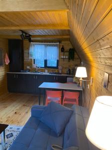 a kitchen and living room with a couch and a table at Sunny Side Cottage in Kazbegi