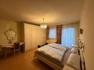 a bedroom with a bed and a desk and a window at Villa Alexander in Bad Hofgastein