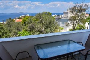 a bench on a balcony with a view of the ocean at Sam's Rooms in Vathí