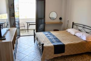 a bedroom with a bed with a mirror and a table at Sam's Rooms in Vathí