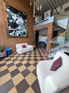 a lobby with two white chairs and a checkered floor at Hotel La Mansión in La Pintada