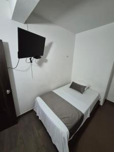 a bedroom with a bed and a flat screen tv at Hotel La Mansión in La Pintada