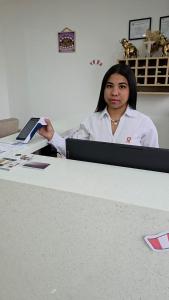 a woman sitting at a desk with a book at Hotel San Cosme in Camaná