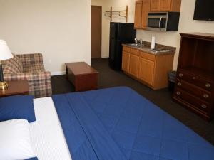 a hotel room with a bed and a kitchen at Tumbleweed Inn & Suites in Alexander