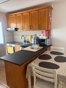 a kitchen with a black counter top and a sink at Casa da Maré in Calheta