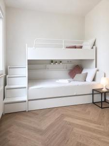 a white bunk bed in a room with a wooden floor at Apartament Premium Orzysz in Orzysz