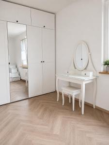 a white bathroom with a dressing table and a mirror at Apartament Premium Orzysz in Orzysz