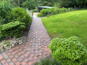 a brick walkway in a yard with a grass field at Las,Jezioro,Masaże,SPA in Ostrzyce