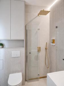 a bathroom with a shower with a toilet and a sink at Apartament Premium Orzysz in Orzysz