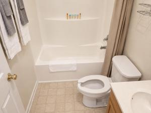 a bathroom with a toilet and a bath tub at Tumbleweed Inn & Suites in Alexander +20 photos