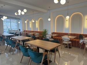 a restaurant with tables and chairs and a couch at Hotel Majestic in Struga