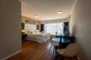 a bedroom with a bed and a table and chairs at Pocitos Plaza Hotel in Montevideo +171 photos