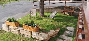 two chairs and flowers in baskets on the grass at Appartamento Oserot in Bersezio