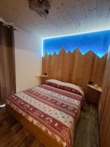 a bedroom with a bed with a wooden wall at Appartamento Oserot in Bersezio