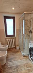 a bathroom with a toilet and a glass shower at Appartamento Oserot in Bersezio