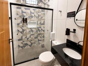 a bathroom with a shower and a toilet and a sink at Hotel Miranda Maracaju in Maracaju +11 photos