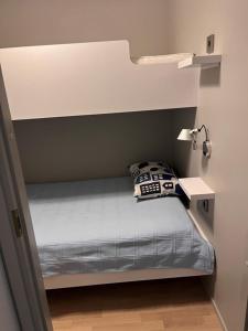 a small bedroom with a bed and a lamp at Vierumäki Chalets 6 A4904 in Heinola