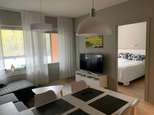 a living room with a room with a bed and a television at Vierumäki Chalets 6 A4904 in Heinola