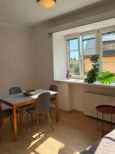 a dining room with a table and chairs and a window at V srdci Telče - Apartmán in Telč