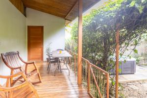 a wooden porch with a table and chairs on it at Colibrí Villa, 800 m from Beach in Uvita