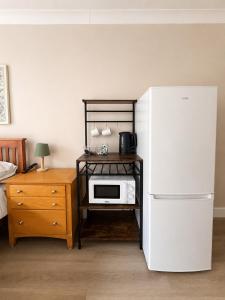 a kitchen with a white refrigerator and a microwave at The Bay Horse Accommodation Contractor Rooms in Carlton