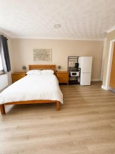 a bedroom with a large bed and a refrigerator at The Bay Horse Accommodation Contractor Rooms in Carlton