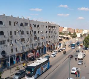 a bus driving down a busy city street with cars at شقة فاخرة موقع ممتاز in Aswan