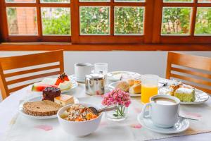 a table with plates of food and cups of coffee at Elite Hotel in Florianópolis