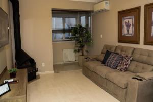 a living room with a couch and a window at Canela Dreams - Stay House Temporada in Canela