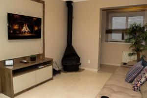 a living room with a couch and a fireplace in the corner at Canela Dreams - Stay House Temporada in Canela +15 photos