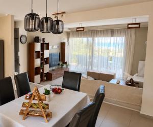 a dining room and living room with a table and chairs at Alkion Villa Sea View, Olive Tree Garden & Spacious Terrace in Rhodes Town