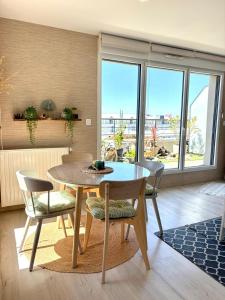 a dining room with a table and chairs with a view at ROOF TOP 50m2 VUE MER !! à 2 mn à pied de la PLAGE et de la THALASSOTHERAPIE ! in Concarneau +11 photos