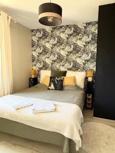 a bedroom with two beds and a wall with a wallpaper at ROOF TOP 50m2 VUE MER !! à 2 mn à pied de la PLAGE et de la THALASSOTHERAPIE ! in Concarneau