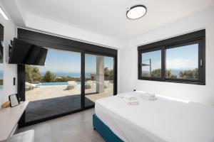 a bedroom with a bed and a large window at Villa Andria in Apolpaina +28 photos