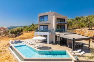 a house with a swimming pool and a villa at Villa Andria in Apolpaina