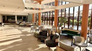 a lobby with chairs and tables and windows at HVD Clubhotel Miramar - 24 Hours Ultra All Inclusive & Free Parking in Obzor