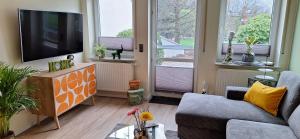 a living room with a tv and a couch and two windows at Ferienwohnung in der Nähe vom Möhnesee-Arnsberg-Breitenbruch in Arnsberg