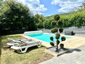 a swimming pool with two lounge chairs and a plant at La Parenthèse - Maison avec piscine privée in Wissembourg
