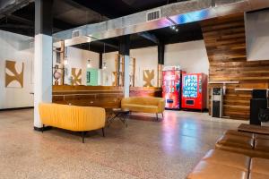 a room with two chairs and a table and two soda machines at Elokut in San Juan