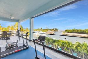 an apartment gym with a view of the ocean at Oceanfront 5BR+ Bonus Room•75’ Dock •Pool-Spa •Kids area •Walk to Sombrero Beach in Marathon +77 photos
